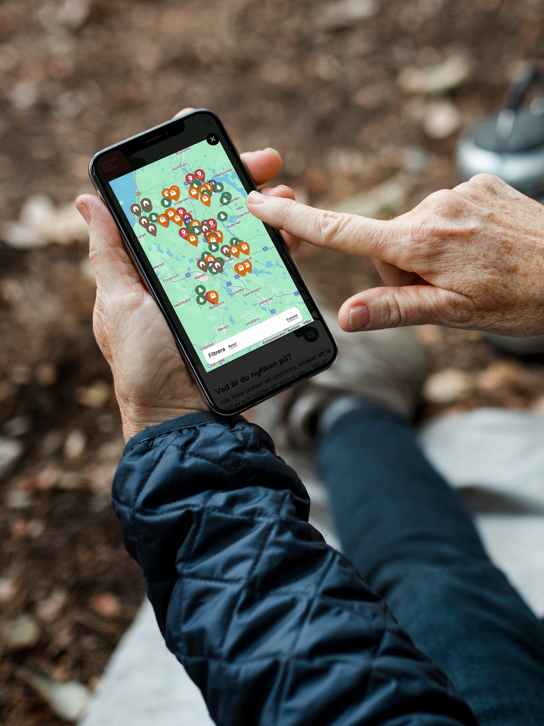 hand pointing at smartphone with a map on the screen